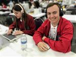 Skylar and Matt in red jackets edit on computer 