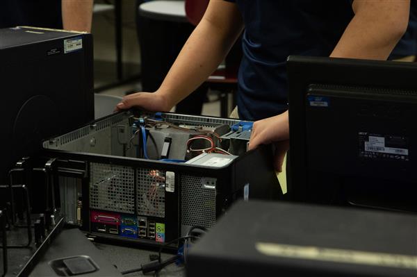 NETWORKING & OPERATING SYSTEMS SECURITY student working on computer